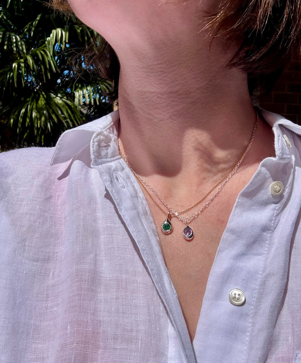 Bronze emerald and sterling silver alexandrite Birthstone Droplet Pendants layered on a gold filled chain and a silver chain, worn in the sunshine