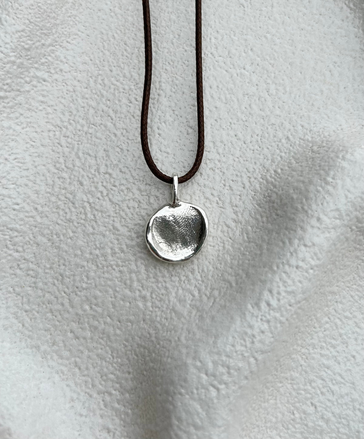 Sterling silver print impression pendant on a leather cord